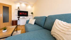 a living room with a blue couch and a table at Boris Garden Comfort Suite in Burgas