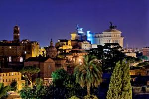 um horizonte da cidade à noite com edifícios e árvores em Fori Imperiali Apartment em Roma