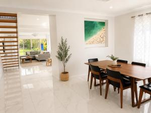 a dining room and living room with a table and chairs at Stunning Sea Facing Bayside House with Pool in Birkdale