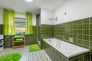 a green tiled bathroom with a tub and a sink at Fleischmannhof Do san ma dahoam in Falkenstein +37 photos