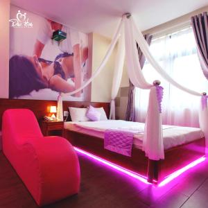 a bedroom with two beds and a red chair at Đào Hoa Mộng Couple Hotel - Central & City View in Quy Nhon
