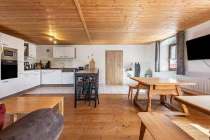 a kitchen and living room with wooden ceilings at Fleischmannhof Do san ma dahoam in Falkenstein