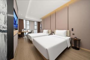 a hotel room with a row of white beds at 北京三里屯天安门亚朵酒店 in Beijing +115 photos