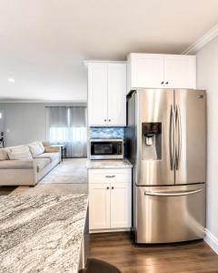a kitchen with a stainless steel refrigerator and white cabinets at Tucked away in Tucker in Tucker