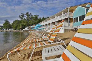 a row of lounge chairs on a beach next to a building at NASWA Resort in Laconia
