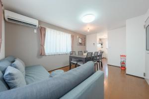 a living room with a blue couch and a table at FUJIMI TOWN HOUSE in Tokyo
