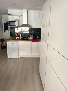 a kitchen with white cabinets and a counter top at Steve's Condo in Davao City