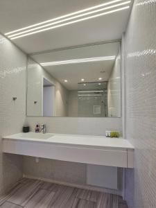 a bathroom with a sink and a large mirror at City Centre Studio Apartments Nicosia in Nicosia +114 photos