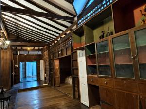a room with wooden walls and a ceiling with beams at Thanomrak homestay in Ban Pha Saeng Lang