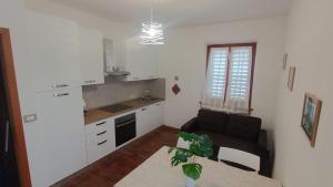a living room with a couch and a kitchen at Casa FerGi in Amandola