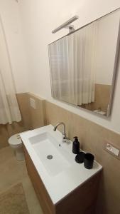 a bathroom with a sink and a toilet and a mirror at Casa FerGi in Amandola +2 photos