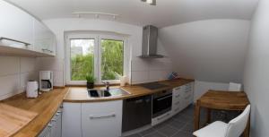 uma cozinha branca com um lavatório e uma janela em Appartement bei Kiel em Lilienthal