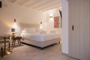 a white bedroom with a bed and a table at Sant Blai Boutique Hotel - Javea in Jávea
