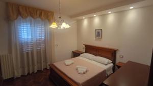 a bedroom with a bed with two towels on it at Casa FerGi in Amandola
