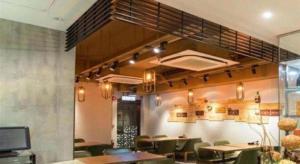 a restaurant with tables and chairs in a room at Metroplace Olympic in Hong Kong