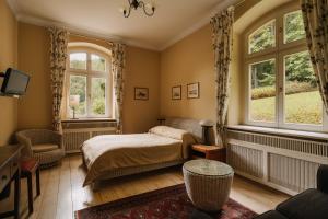 a bedroom with a bed and two windows at Villa Titina in Miedzygorze