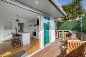 a kitchen and dining room with a deck with a table and chairs at Sea-Renity Picton, Apt B in Picton