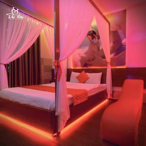 a bedroom with a bed with pink lighting at Đào Hoa Mộng Couple Hotel - Central & City View in Quy Nhon +7 photos