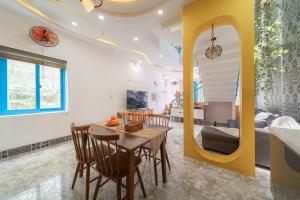 a dining room and living room with a table and chairs at Lazy Bear Villa By The Little Hoi An in Hoi An