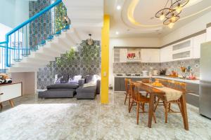 a kitchen and a living room with a dining table and a staircase at Lazy Bear Villa By The Little Hoi An in Hoi An