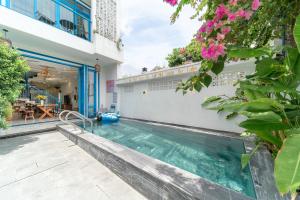 a swimming pool in the courtyard of a building at Lazy Bear Villa By The Little Hoi An in Hoi An
