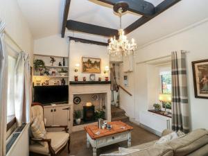 a living room with a fireplace and a chandelier at Prospect Cottage in Sowerby Bridge