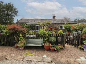a house with a bench in front of a fence at Prospect Cottage in Sowerby Bridge