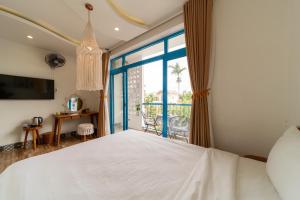 a bedroom with a large white bed and a balcony at Lazy Bear Villa By The Little Hoi An in Hoi An +32 photos