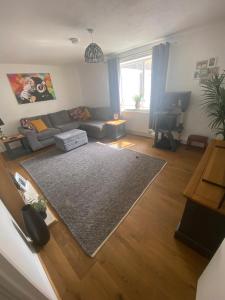 a living room with a couch and a television at 5 Star Large Double Room in Hull with Free Parking & WIFI in Anlaby