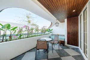 a room with a table and chairs on a balcony at Nuho Living in Bingin Beach