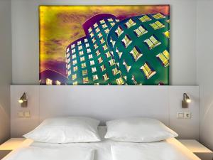 a bedroom with a large painting above a bed at Wyndham Garden Düsseldorf City Centre Königsallee in Düsseldorf