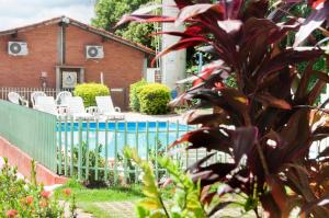 a house with a fence and chairs in a yard at Bonito HI Hostel e Pousada in Bonito
