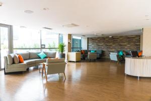 a lobby with a couch and tables and chairs at Novotel RJ Porto Atlantico in Rio de Janeiro