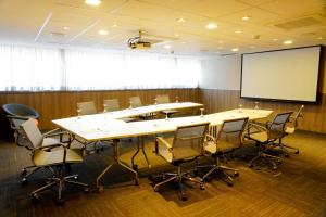 a conference room with a table and chairs and a screen at Novotel RJ Porto Atlantico in Rio de Janeiro