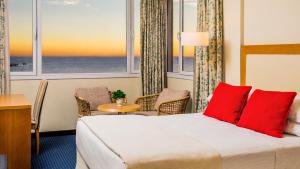 玛德琳港瓦尔德斯半岛酒店的配有红色枕头的床的酒店客房