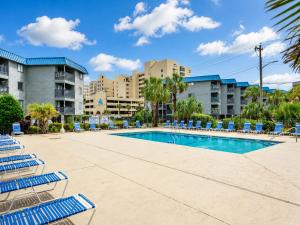 a swimming pool with blue lounge chairs and buildings at Oceanfront 1BR • Top-Floor Balcony Views • Cherry Grove • Sea Cabin 304-A in Myrtle Beach