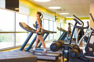 a woman walking on a treadmill in a gym at Novotel RJ Porto Atlantico in Rio de Janeiro