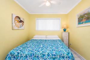 a bedroom with a bed with a blue blanket at Oceanfront 1BR • Top-Floor Balcony Views • Cherry Grove • Sea Cabin 304-A in Myrtle Beach