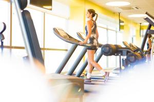 a woman walking on a treadmill in a gym at Novotel RJ Porto Atlantico in Rio de Janeiro
