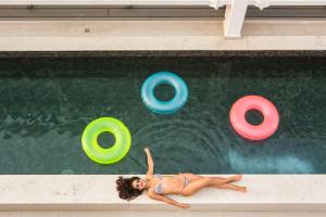 a woman laying in a swimming pool with frisbees at Novotel RJ Porto Atlantico in Rio de Janeiro