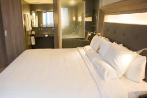 a bedroom with a large bed with white pillows at Novotel RJ Porto Atlantico in Rio de Janeiro