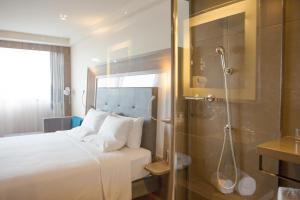 a hotel room with a bed and a shower at Novotel RJ Porto Atlantico in Rio de Janeiro