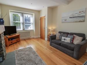 a living room with a couch and a television at Haven Cottage in Kirkcudbright