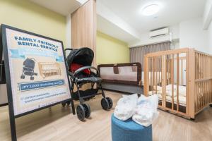 a room with two bunk beds and a sign and a crib at ESLEAD HOTEL Namba East in Osaka +35 photos