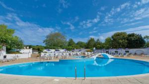 a large swimming pool in a resort with a blue sky at The Belmont Hotel in Sidmouth