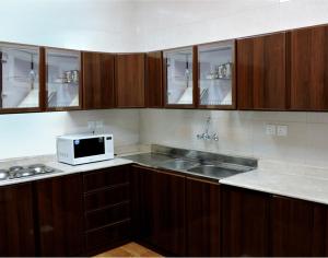 a kitchen with a sink and a microwave at Qasr Allathqiah Furnished Apartment 4 in Khamis Mushayt
