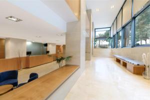 an office lobby with a long table and blue chairs at Catalonia Barcelona Beach in Barcelona