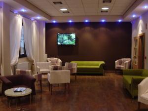 a waiting room with a green couch and chairs at Hospedaje La Tortuga in Santoña