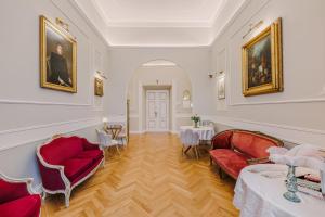 a living room with red furniture and paintings on the walls at Maison 31 - Unique Experience in Civitavecchia