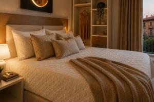 a bedroom with a large bed with pillows at Syraka Design Rooms & Suites in Syracuse